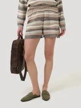 Short tejido de punto a rayas horizontales en tonos beige, blanco y marrón. Cuenta con cintura elástica y forro interno. El ruedo tiene un detalle calado.