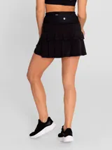 Falda deportiva negra con calza interior, de secado rápido. Diseño acampanado con plisado en la parte trasera, pretina ancha con bolsillo con cierre y bolsillo interior en la calza.