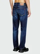 Jeans de hombre Diesel modelo D-Strukt, corte slim, en denim azul oscuro con efecto desgastado y lavado que se aclara hacia las rodillas y los muslos.