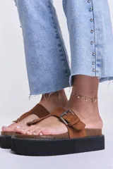 Sandalia flatform color camel, con tira entre los dedos y hebilla lateral ajustable.