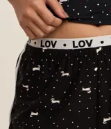 Short de pijama negro con estampado de perritos blancos y cintura elástica con la inscripción "LOV".