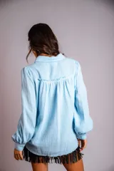 Camisa color beige de muselina con bordado en la parte delantera y manga globo con puño.