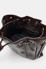 Bolso tipo saca de cuero sintético marrón oscuro, con fruncido superior ajustable mediante cordón. Posee asa de hombro con detalle de cadena metálica oscura y bolsillo interior con cierre.