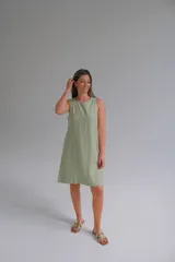 Vestido verde claro de lino italiano con escote redondo, sin mangas, corte recto y largo a la rodilla.