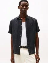 Camisa de manga corta azul marino de lino con corte regular, cuello con botones y logo de Tommy Hilfiger bordado en el pecho.