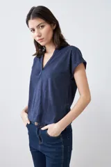Remera color beige melange con escote en V y media cartera con botones.