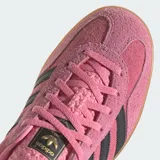 Championes Adidas Gazelle Indoor color rosa con las tres tiras laterales en negro y suela de goma color caramelo.