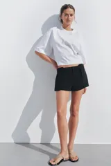 Camiseta blanca de algodón, corte oversize, cuello redondo, manga corta y detalle de aplique metálico con logo ZA en el frente.