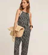 Mono largo de viscosa con estampado geométrico en blanco y negro. Tiene escote cuadrado, breteles medianos, lazo en la cintura y bolsillos laterales.