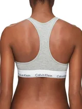 Bralette deportivo Calvin Klein Modern Cotton, color gris, sin relleno ni forro, con espalda cruzada y banda inferior elástica blanca con logo de la marca.