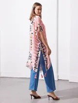 Kimono tejido con estampado abstracto en tonos beige, blanco y negro. Tiene mangas amplias estilo japonés y terminación de ruedo con borlas.