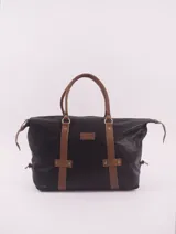 Bolso de viaje negro con detalles en cuero marrón, doble asa de mano y cierre superior con cremallera.
