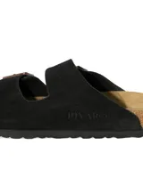 Sandalias planas de dos tiras ajustables, color negro, con hebillas metálicas color cobre. La plantilla es de corcho y látex, con forro de gamuza.