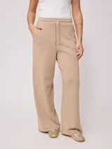 Pantalón deportivo jogger color beige, de pierna ancha y corte holgado.