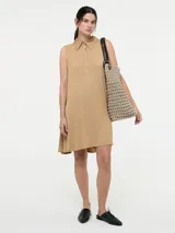 Vestido sin mangas color tostado con cuello camisero y botones frontales, equipado con bolsillos laterales.