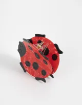 Broche acrílico con forma de vaquita de San Antonio, color rojo con lunares negros.