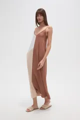 Vestido largo, holgado, con breteles finos y escote en V. Presenta un diseño de bloques de color en tonos blanco, beige claro y marrón.