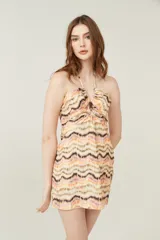 Minivestido con estampado zig-zag en tonos beige, naranja y marrón, con escote halter y espalda descubierta.