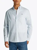 Camisa celeste de manga larga, confeccionada en algodón y lino, con cuello abotonado, cierre con botones, corte regular y logo de Tommy Jeans bordado en el pecho.