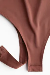Body colaless marrón de punto elástico suave con escote redondo y botones a presión ocultos en la entrepierna.