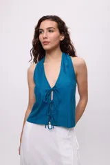 Chaleco azul con escote halter y tiras en el frente para regular.