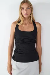 Musculosa negra con escote halter y corte ajustado.