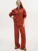 Pantalón de lino color marrón claro, de pierna ancha y tiro alto. Presenta un pequeño elástico en la parte trasera de la pretina y detalle al costado tipo naval.