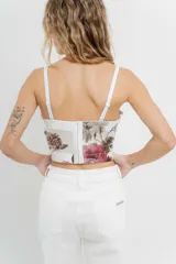 Top tipo corset con estampa floral, confeccionado en tul elástico con estructura interna y copas armadas. Breteles regulables y cierre con triple hilera de broches en espalda.
