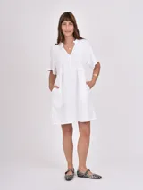 Vestido corto blanco de corte suelto, con escote en V y mangas cortas con volados.