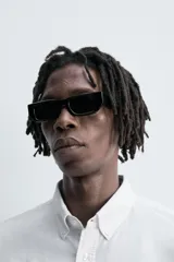 Camisa de algodón color celeste claro, corte regular fit, con cuello abotonado (button-down), manga larga con puño abotonado y bolsillo de parche en el pecho izquierdo.