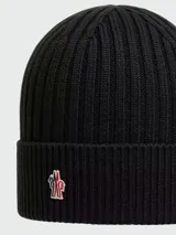 Gorro de lana tejido a punto acanalado, color marrón oscuro, con el logo de Moncler bordado en la parte frontal.