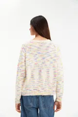 Sweater de punto color crudo con motas de colores pastel, de corte clásico y cuello redondo.