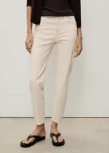 Pantalón de jean color crudo, corte mom fit, tiro alto, cinco bolsillos y cierre con cremallera y botón.