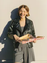 Bermudas grises de tiro medio con cierre combinado, pliegues y pasadores para cinturón.