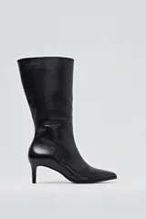 Bota de caña media de cuero negro, con punta fina y taco aguja de altura media.