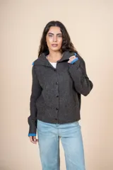 Cárdigan de tejido con relieve color gris, con cuello camisero, botones al frente y detalles de color celeste en cuello y puños.