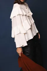 Blusa de lino color blanco, con silueta oversize, cuello bote y volados en el frente.