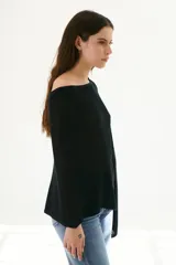 Poncho color beige de tejido de punto con cuello asimétrico.