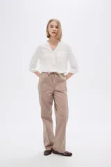Pantalón de algodón color beige, de corte recto y tiro medio, con bolsillos laterales y cintura con cordón ajustable.