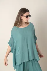 Blusa italiana color verde militar, de lino y algodón, con calado en los costados y espalda, calce holgado y dos bolsillos delanteros.