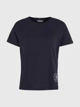 Remera azul marino de cuello redondo y manga corta, confeccionada en algodón. Presenta un logo de Tommy Hilfiger en el lateral inferior.