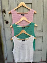 Blusa sin mangas de tejido de punto calado, color celeste, con cuello redondo.