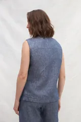 Chaleco color crema de lino, con cuello mao, cierre frontal con botones y bolsillos ojal a contratono.