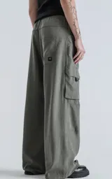 Pantalón cargo gris con cintura elástica, bolsillos laterales con solapa y corte oversize.