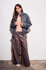 Campera acolchada gris oscuro con efecto lavado, cuello mao y cierre frontal. Presenta un patrón de costura ondulado.