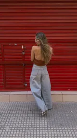 Pantalón de jean celeste de tiro medio con pierna extra ancha y caída fluida, con bolsillos delanteros y traseros, y cierre frontal con cremallera y botón metálico.
