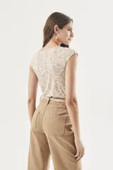 Remera blanca con estampado de lunares marrones, corte al cuerpo y mangas cortas.