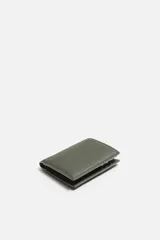 Billetera vertical negra de cuero texturizado con compartimento para billetes y tres ranuras para tarjetas en cada lado.