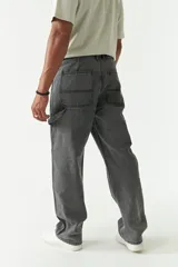 Pantalón jean celeste de corte amplio, estilo carpenter, con bolsillos laterales y logo bordado.