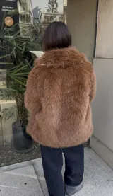 Campera de pelo sintético color beige, con cuello solapa, cierre con botones y bolsillos laterales.